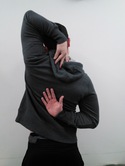back view of person with left hand touching back of neck and right hand touching middle of back