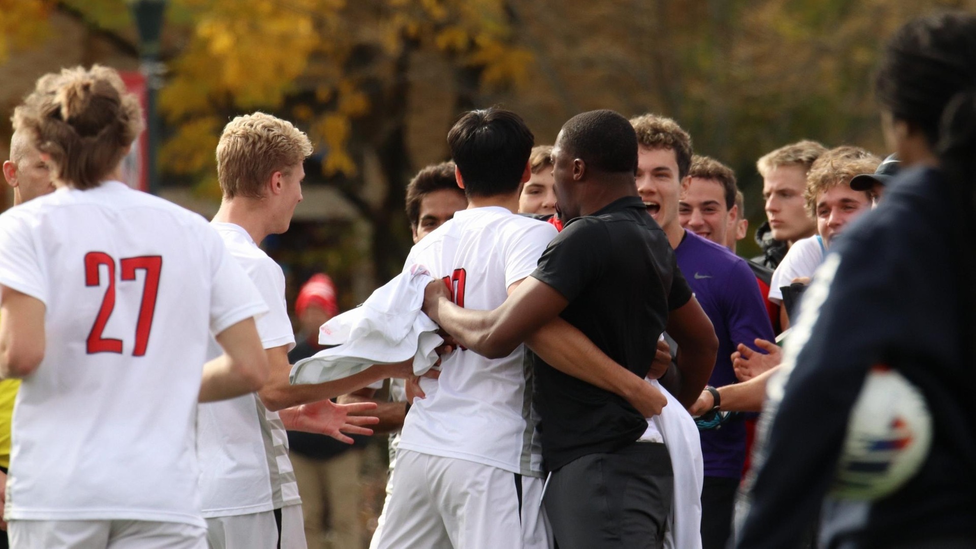 group of men's soccer players celebrating after a goal