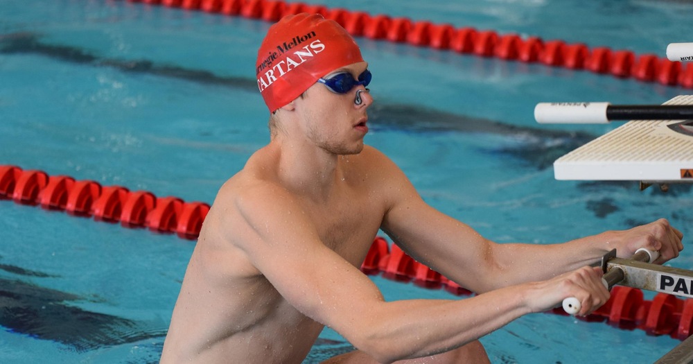 men's swimmer wearing red cap about to start backstroke