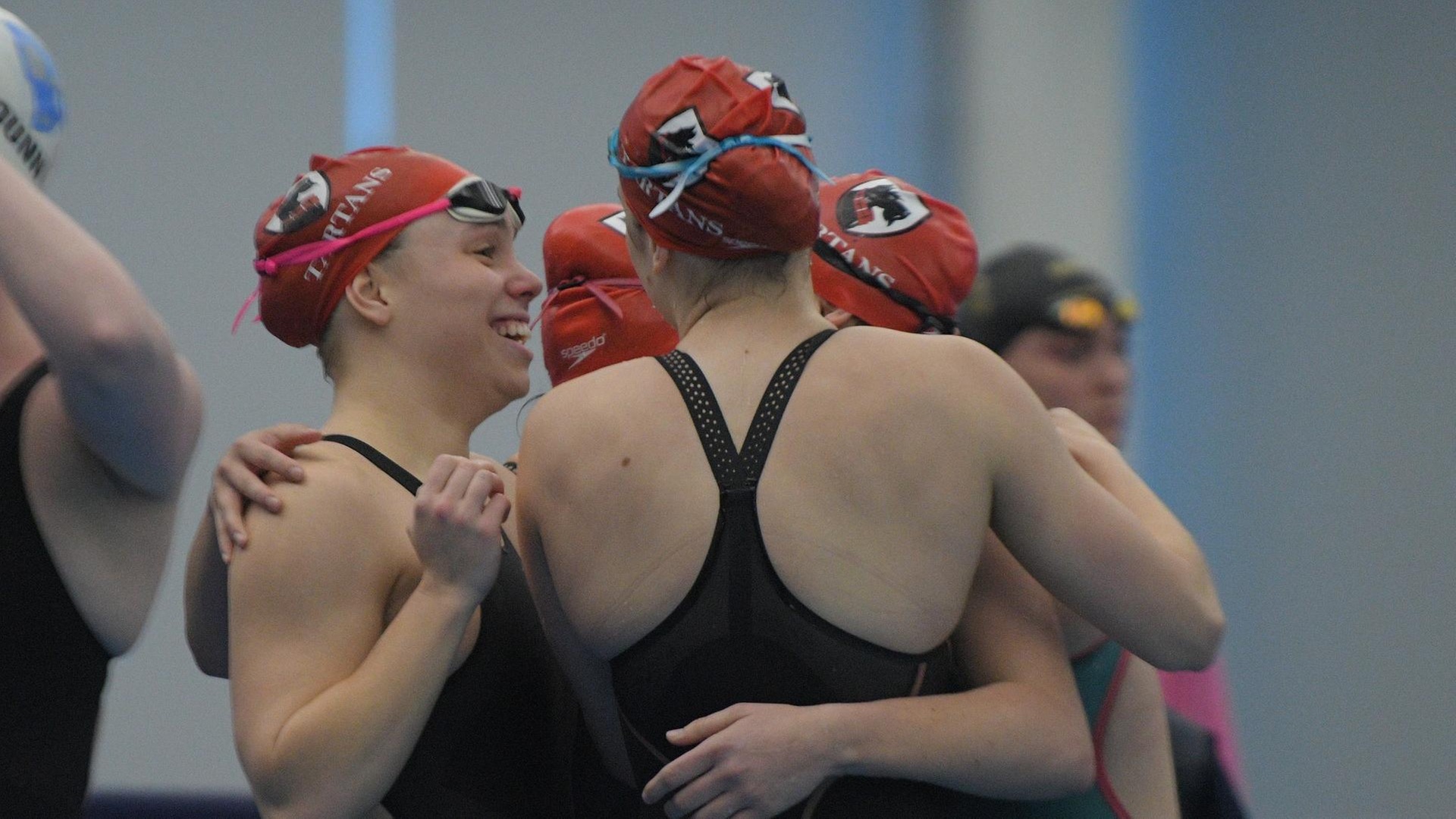 group of women's swimmers hugging