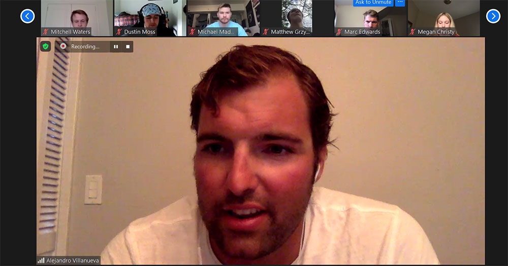 Zoom meeting with main speaker, a male in a white shirt, in the main portion of the screen with participants along the top 