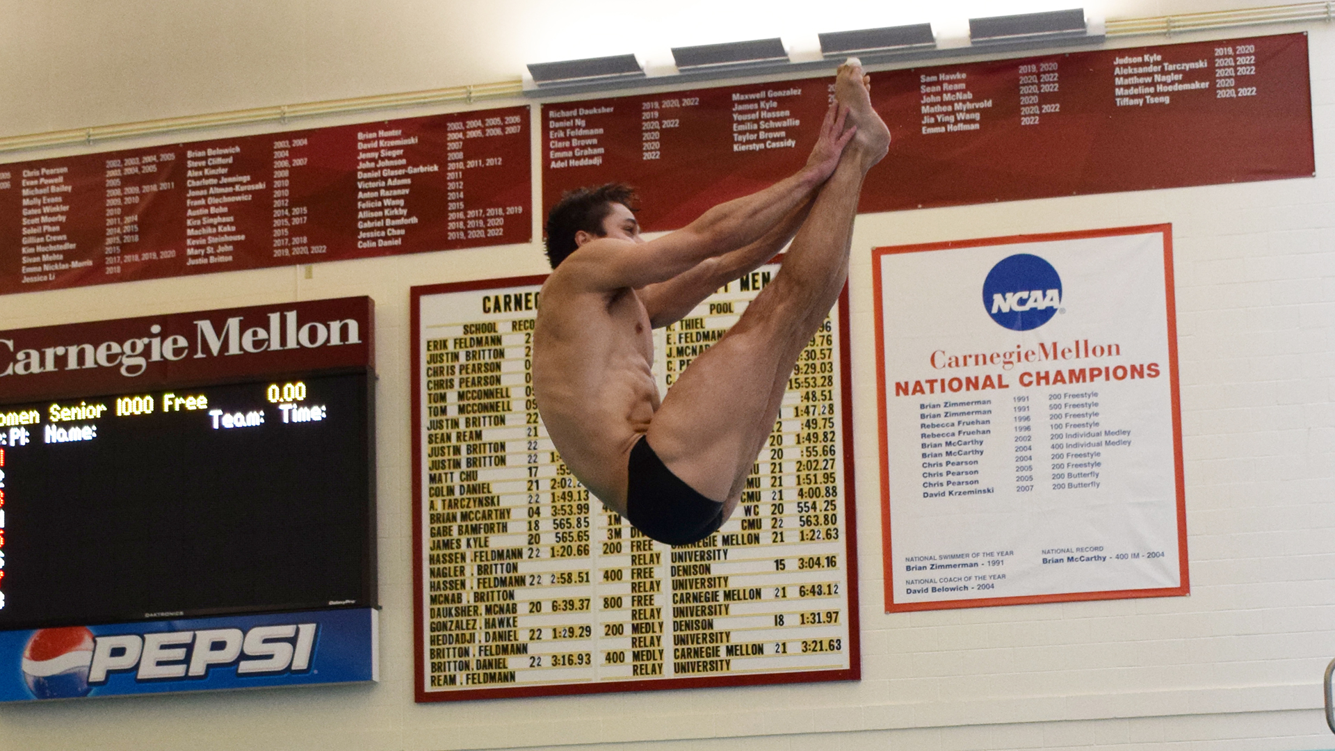 men's diver touching toes in air