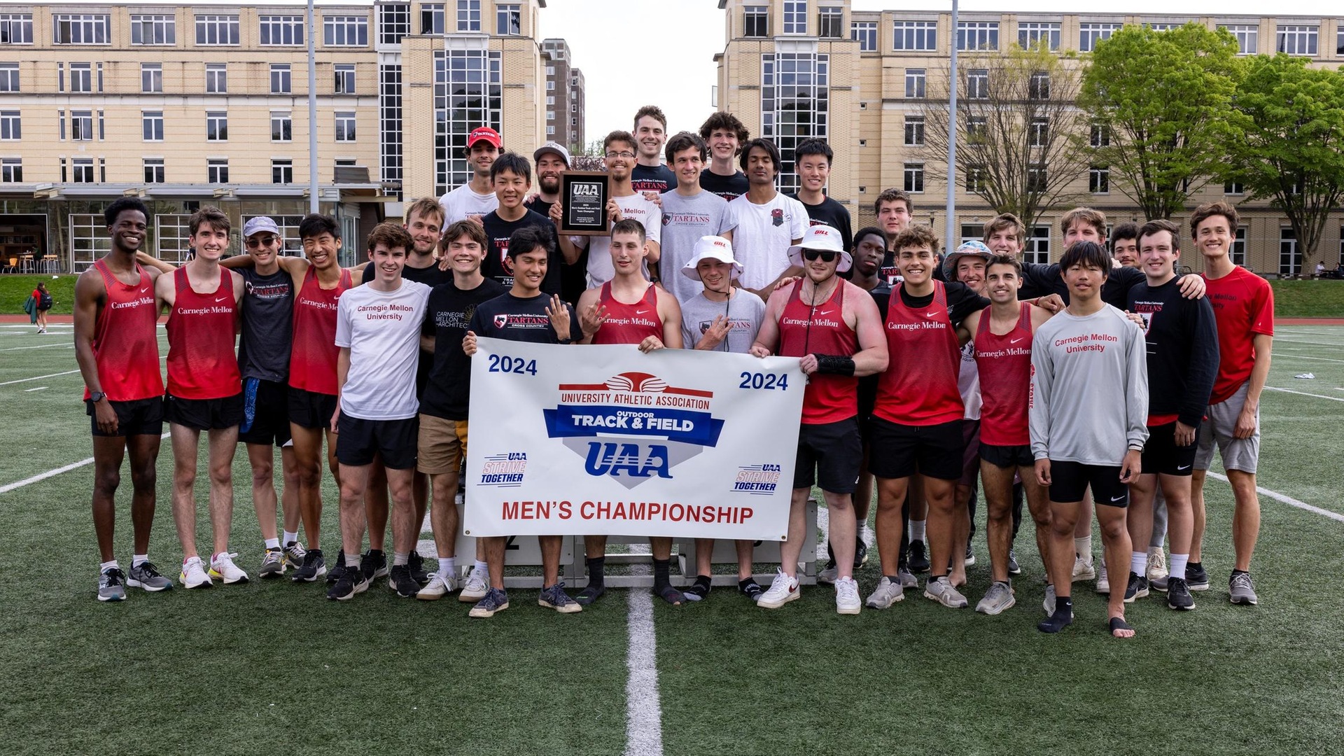 team photo of men's track team holding a championship banner