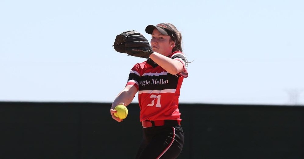 women's softball pitcher in mid-motion with glove near face