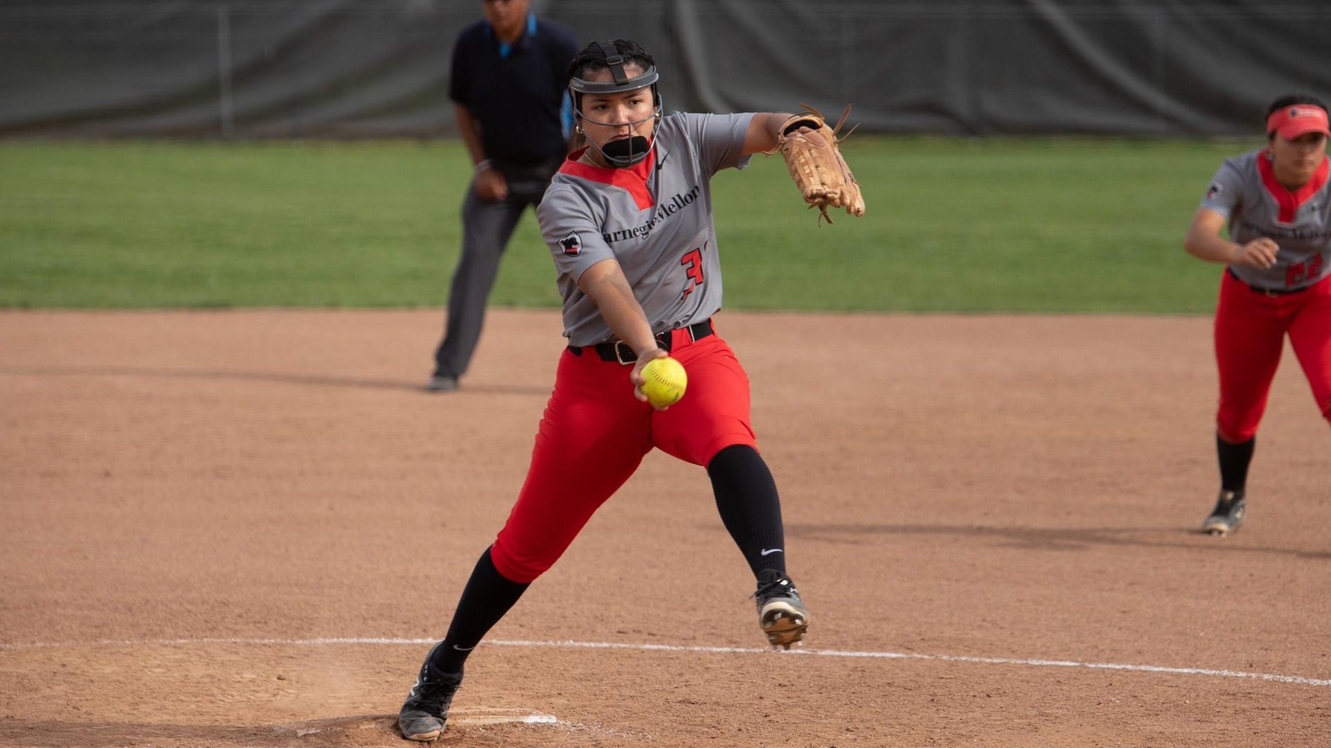 women's softball pitcher in mid-motion about to release pitch