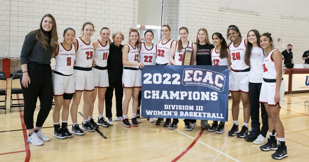 group photo of women's basketball team holding a championship banner