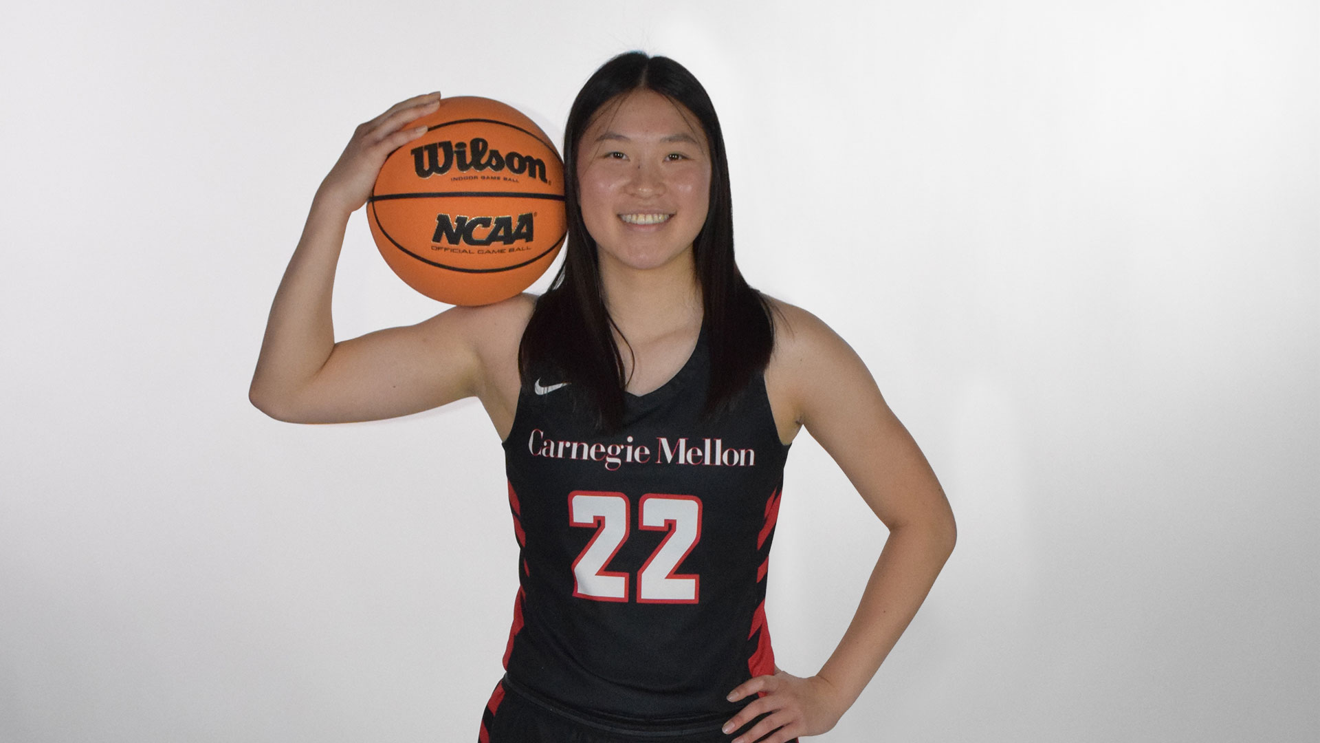 women's basketball player holding the ball on her shoulder