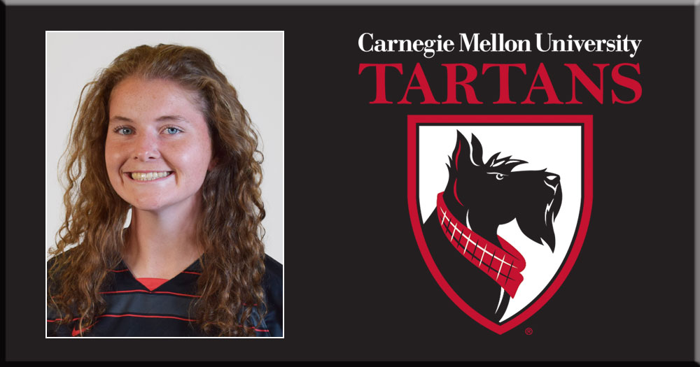 portrait photo of a woman with curly hair wearing a black shirt with the Carnegie Mellon University Tartans Logo to the  right