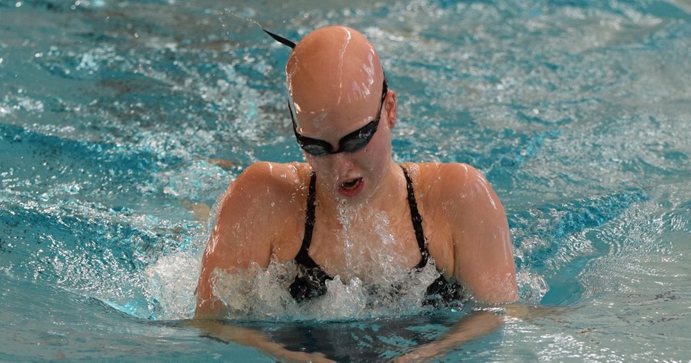women's swimmer in middle of breaststroke event