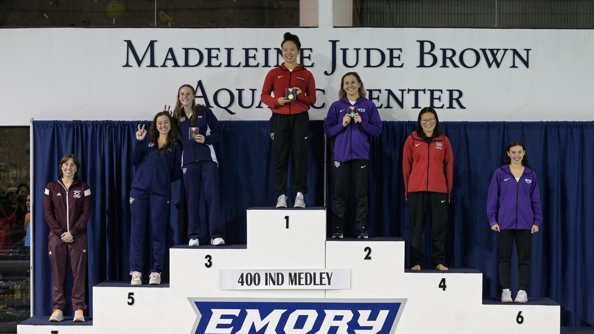women standing on a tiered podium