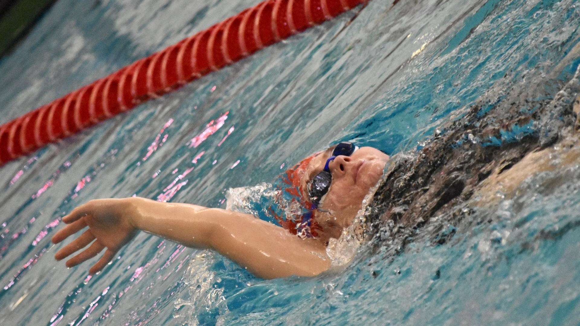 women's swimmer in backstroke motion