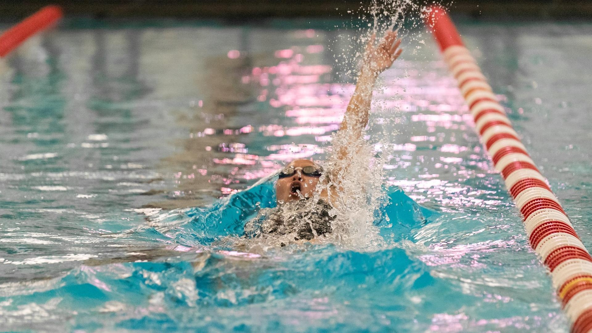 women's swimmer doing backstroke away from point of view