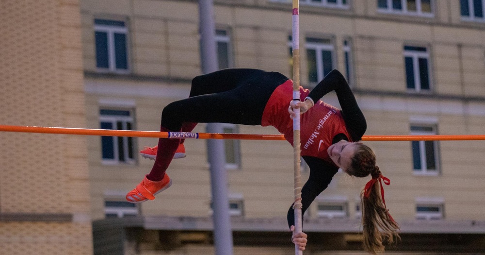 women's athlete clearing the pole vault bar