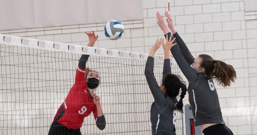 Volleyball player with a kill attempt with two blockers near the net