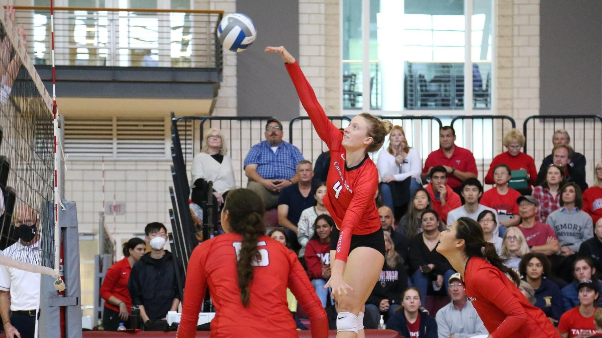 women's volleyball player jumping and swinging at a ball with her right arm