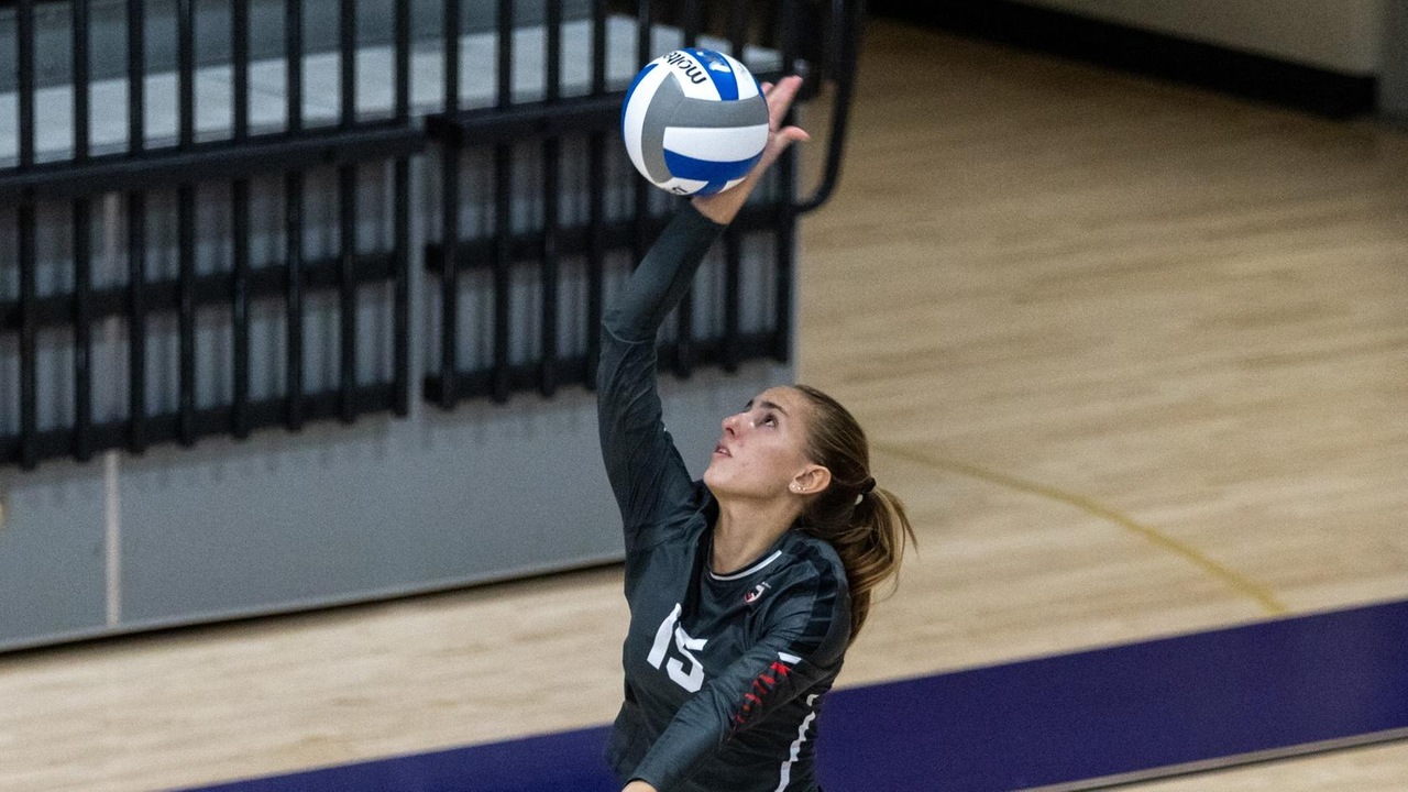 women's volleyball player jumping to hit the ball for a serve
