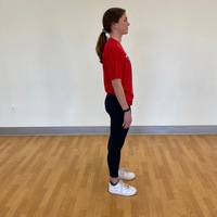 side profile of person standing straight with arms at side